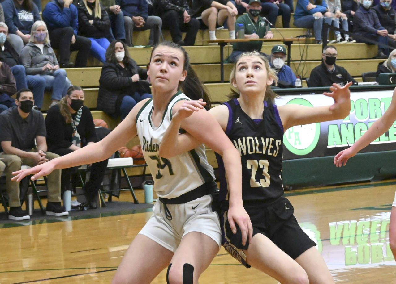 Port Angeles’ Lexie Smith, left and Sequim’s Lauryn Stephens battle for rebounding positions. (Michael Dashiell/Olympic Peninsula News Group)
