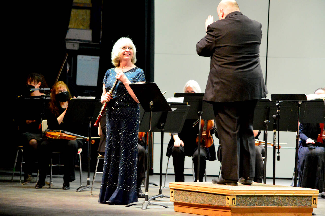 Oboe soloist Anne Krabill of Port Townsend, having just performed Jean Francaix’ “Flower Clock” concerto with the Port Angeles Symphony, is applauded by conductor Jonathan Pasternack during Saturday’s morning concert. Krabill and the orchestra received a standing ovation from the capacity audience at the Port Angeles High School Performing Arts Center. (Diane Urbani de la Paz/Peninsula Daily News)