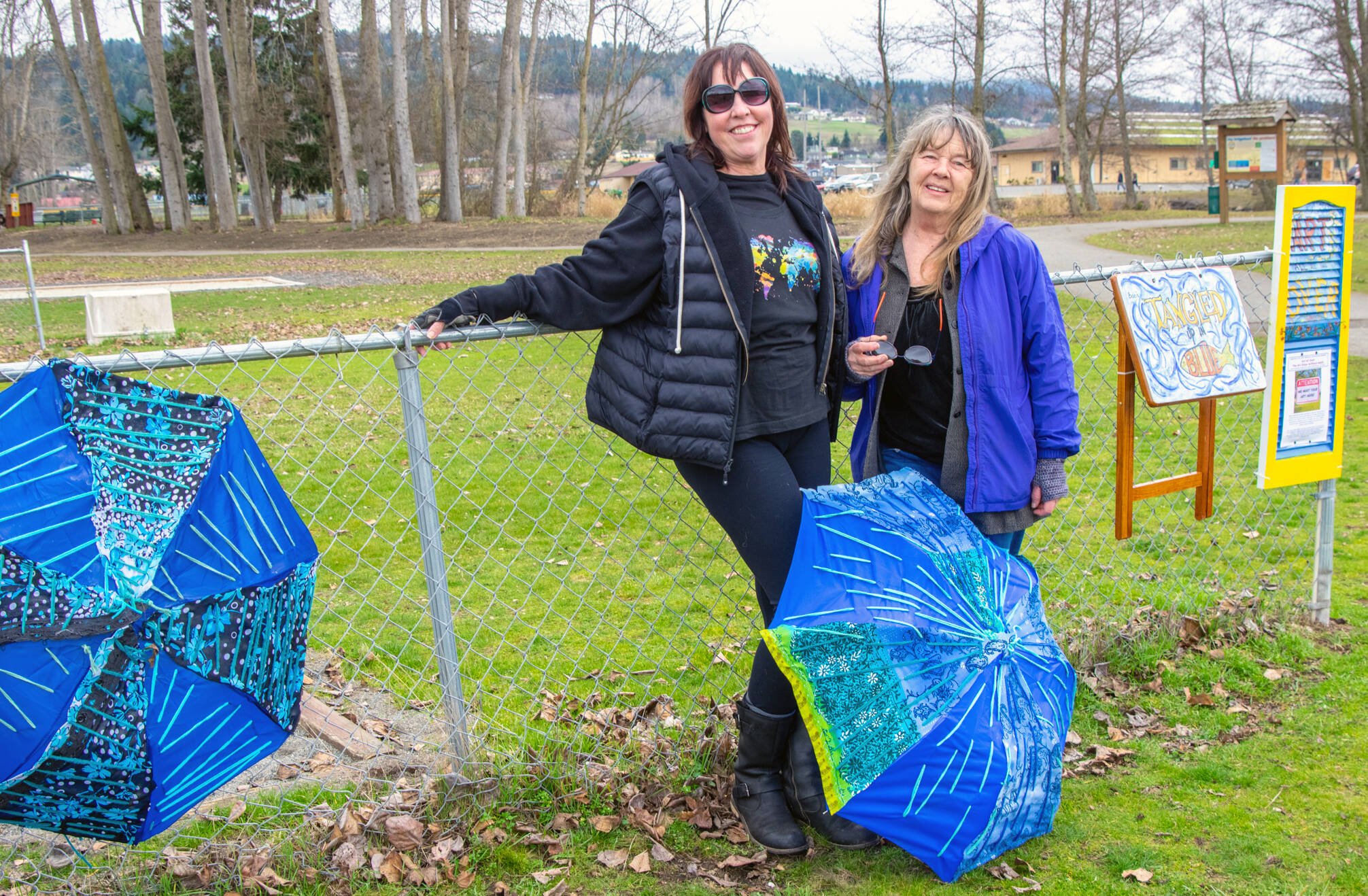 Emily Matthiessen / Olympic Peninsula News Group
Brigitte Schlemmer and Suzanne Horne hang the first pieces for “Art All Over — The Art Show Without Walls,” this past weekend at Carrie Blake City Park.