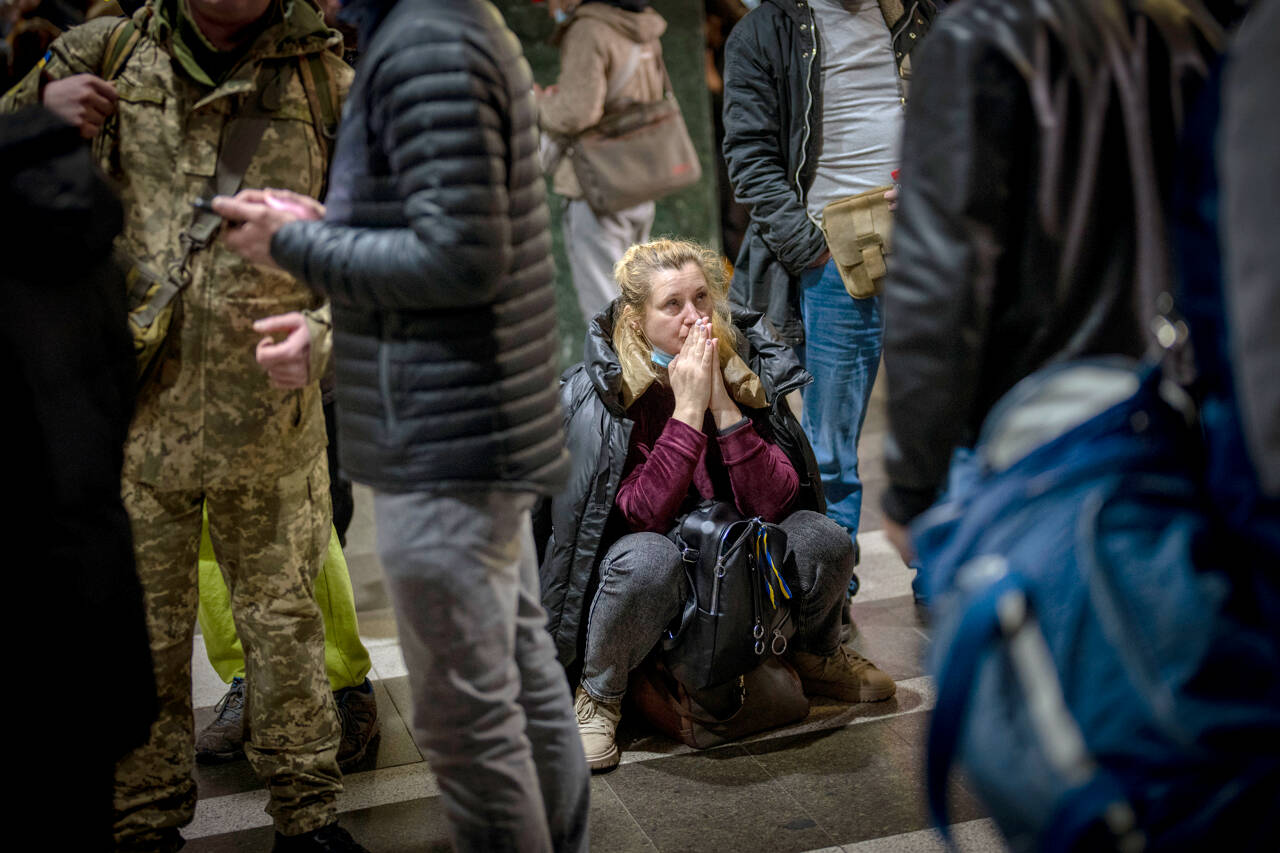 A woman reacts as she waits for a train trying to leave Kyiv, Ukraine, on Thursday. Russian troops have launched their anticipated attack on Ukraine. (Emilio Morenatti / The Associated Press)