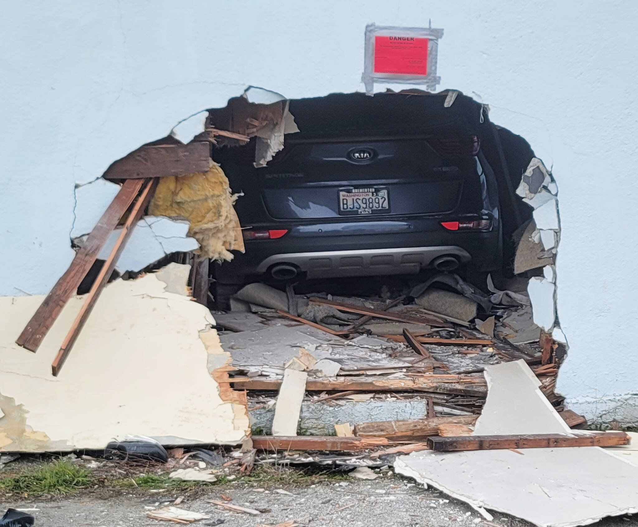A car that was out of control because of the driver’s medical emergency lodged within an apartment building in Port Angeles on Saturday. (Van Hurst/For Peninsula Daily News)