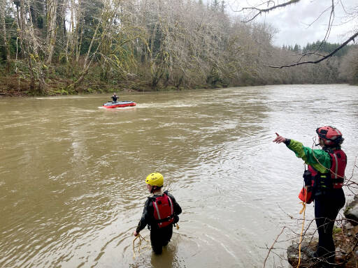 A swift-water rescue team from Clallam County Fire District 1 works to bring a man to shore after an inflatable raft overturned Sunday in the Calawah River. (Clallam County Fire District 1)