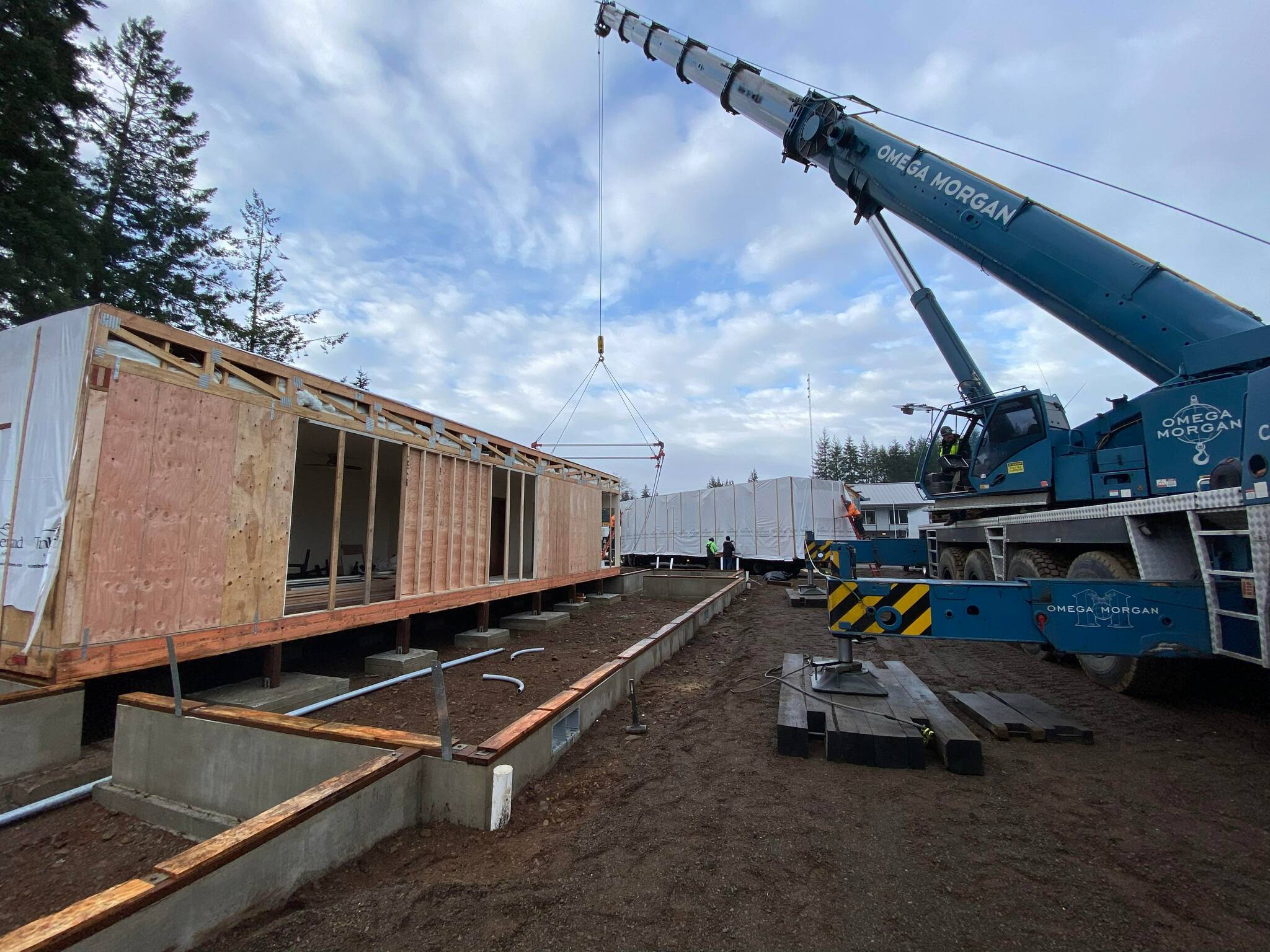 A large crane was used to place the modules onto the prepared foundation.
A large crane was brought in from Seattle to put the Hobucket House into place. (North Olympic Regional Veterans Housing Network)