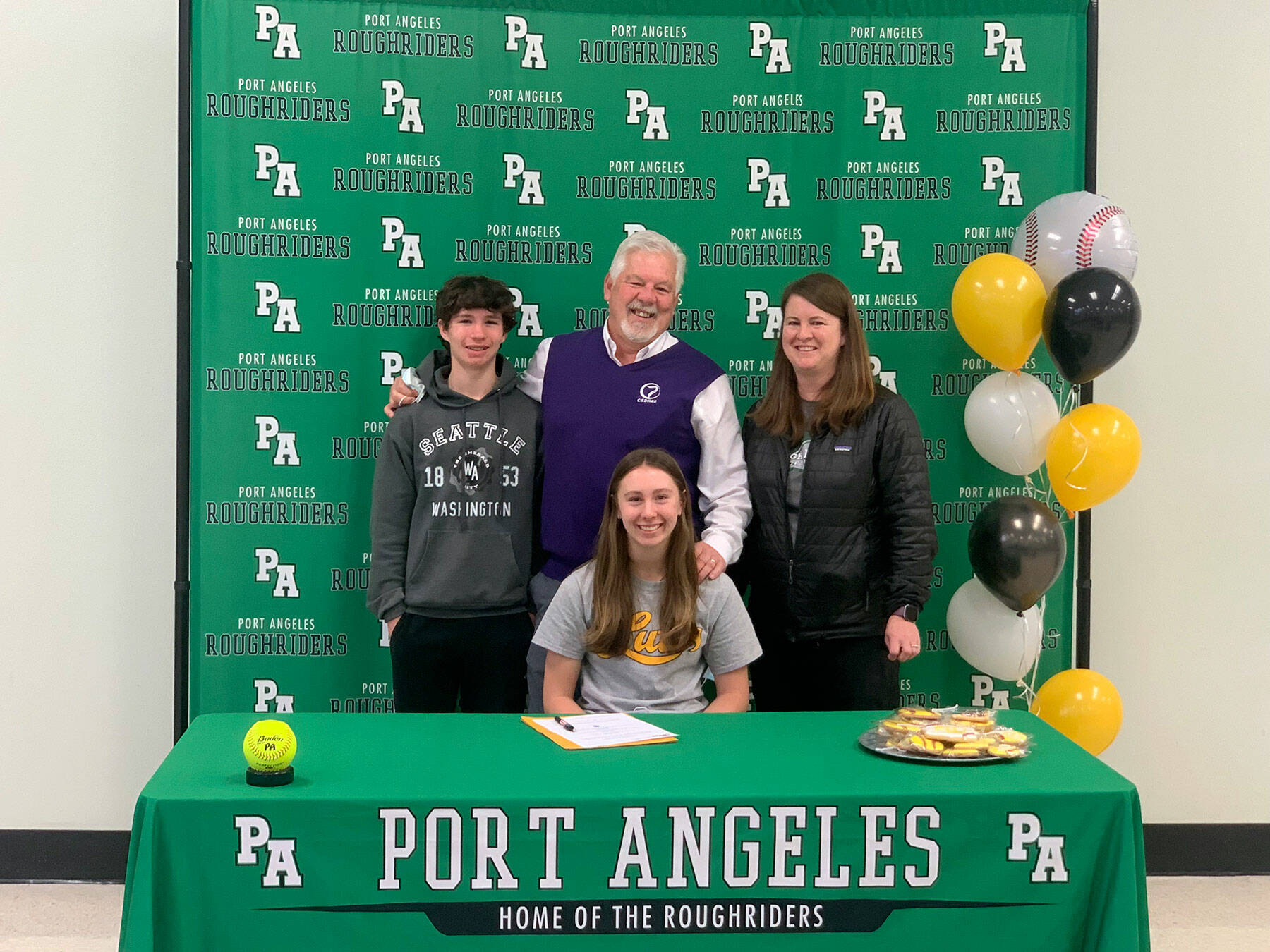 Port Angeles’ Zoe Smithson, seated, recently signed a letter of intent to play softball at Pacific Lutheran University in Parkland. Smithson is joined by, from left, her brother Ian, dad Larry and mom Staci.