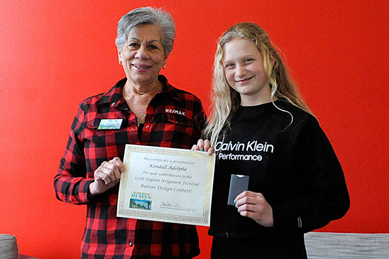 Matthew Nash/Olympic Peninsula News Group

Liz Parks, president of RE/MAX Prime, presents fifth grader Kendall Adolphe with a certificate and gift card for winning the Sequim Irrigation Festival’s button design contest.