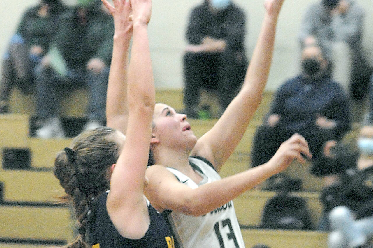 Keith Thorpe/Peninsula Daily News
Port Angeles' Bailee Larson, right, scores on a layup against Bainbridge in Port Angeles in December. Larson is one of the Roughriders' top players and passers.