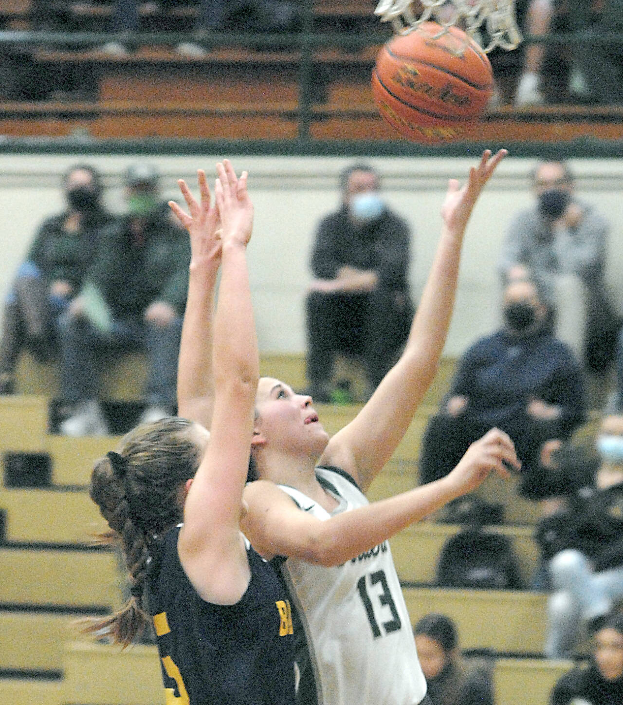 Port Angeles Bailee Larson, right, scores on a layup against Bainbridge in Port Angeles in December. Larson is one of the Roughriders top players and passers. (Keith Thorpe/Peninsula Daily News)