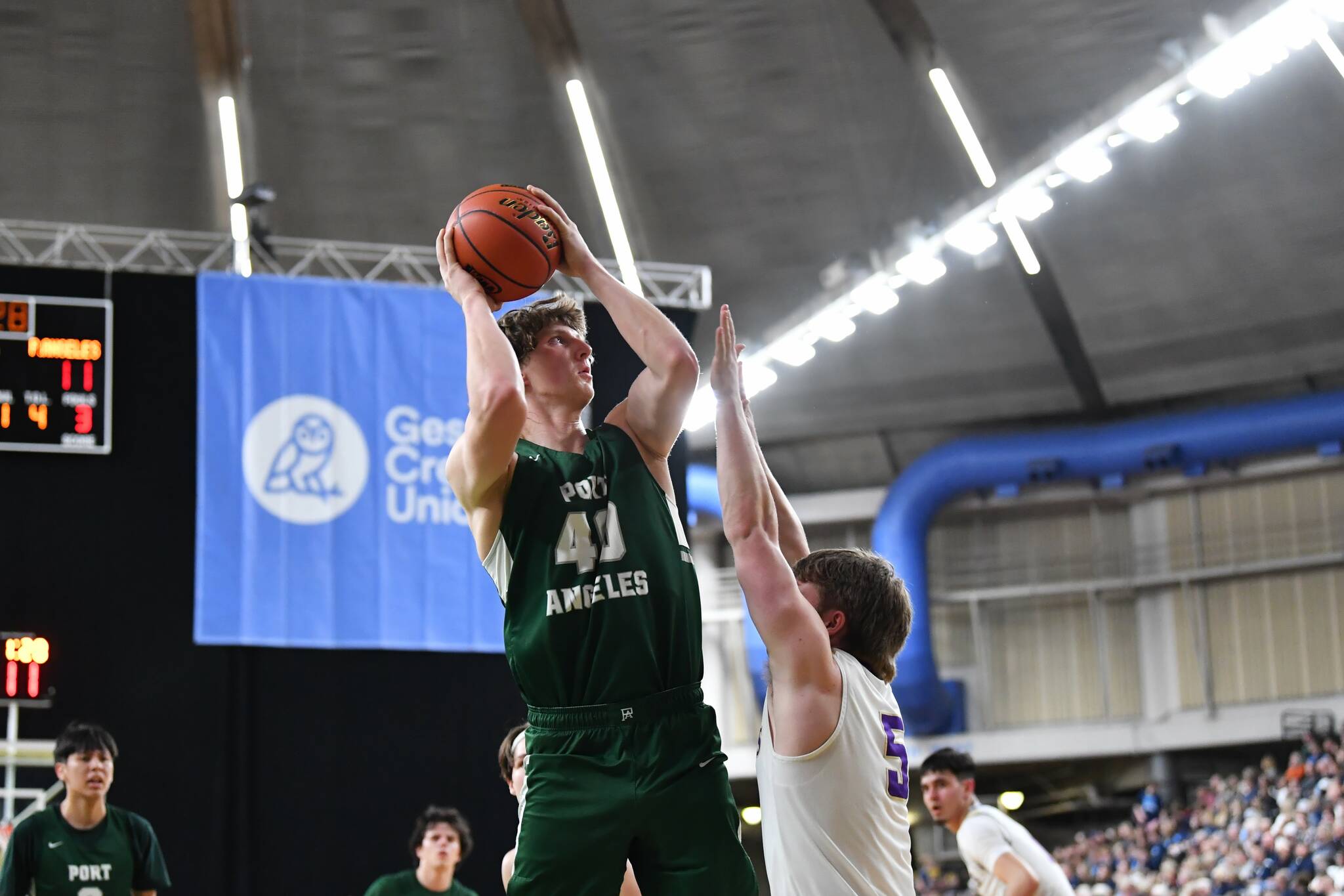 Jordan Nailon/The Daily News Port Angeles John Vaara puts up a shot over North Kitsaps Colton Bower during the Roughriders 75-58 Class 2A state quarterfinal loss Thursday at the Yakima SunDome