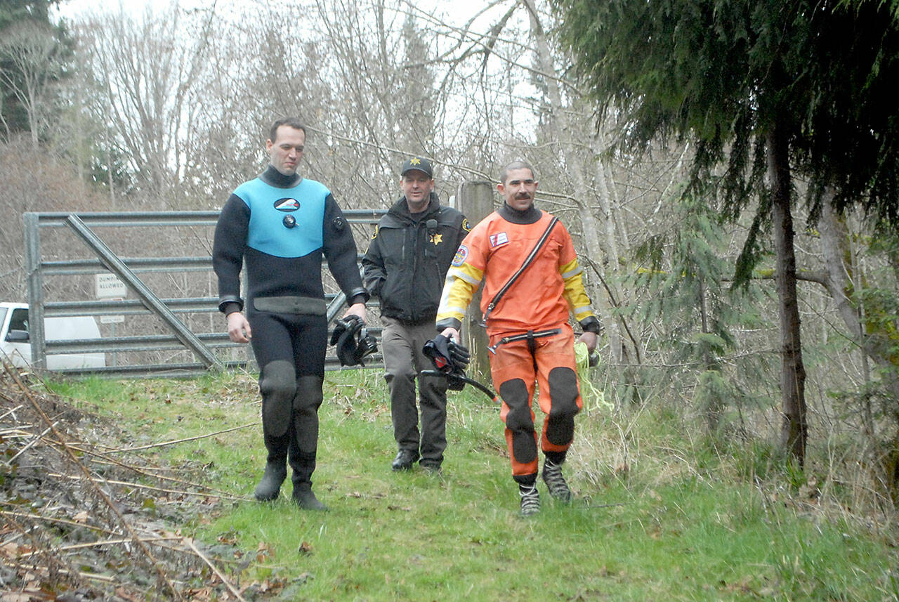 Clallam County Sheriff’s deputies Dylan Heck, left, and Hector Eagan, right, accompanied by Sgt. John Keegan, prepare to search for evidence on Friday in a section of nearby Siebert Creek in the Feb. 24 double homicide east of Port Angeles. (Keith Thorpe/Peninsula Daily News)