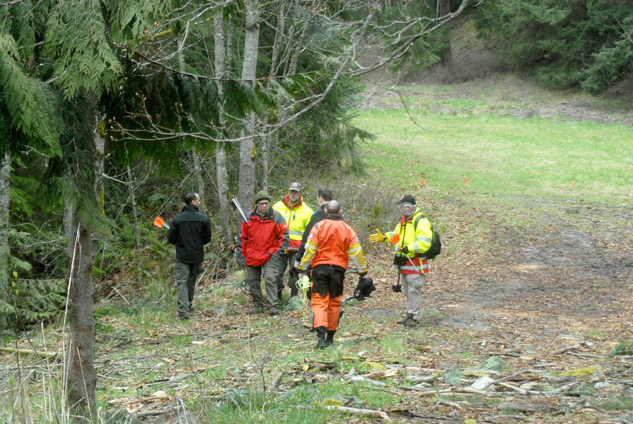 Clallam County Search and Rescue members and sheriff’s deputies prepare to search in the woods near Wild Current Way on Friday for possible evidence in a Feb. 24 double homicide east of Port Angeles. (Keith Thorpe/Peninsula Daily News)
