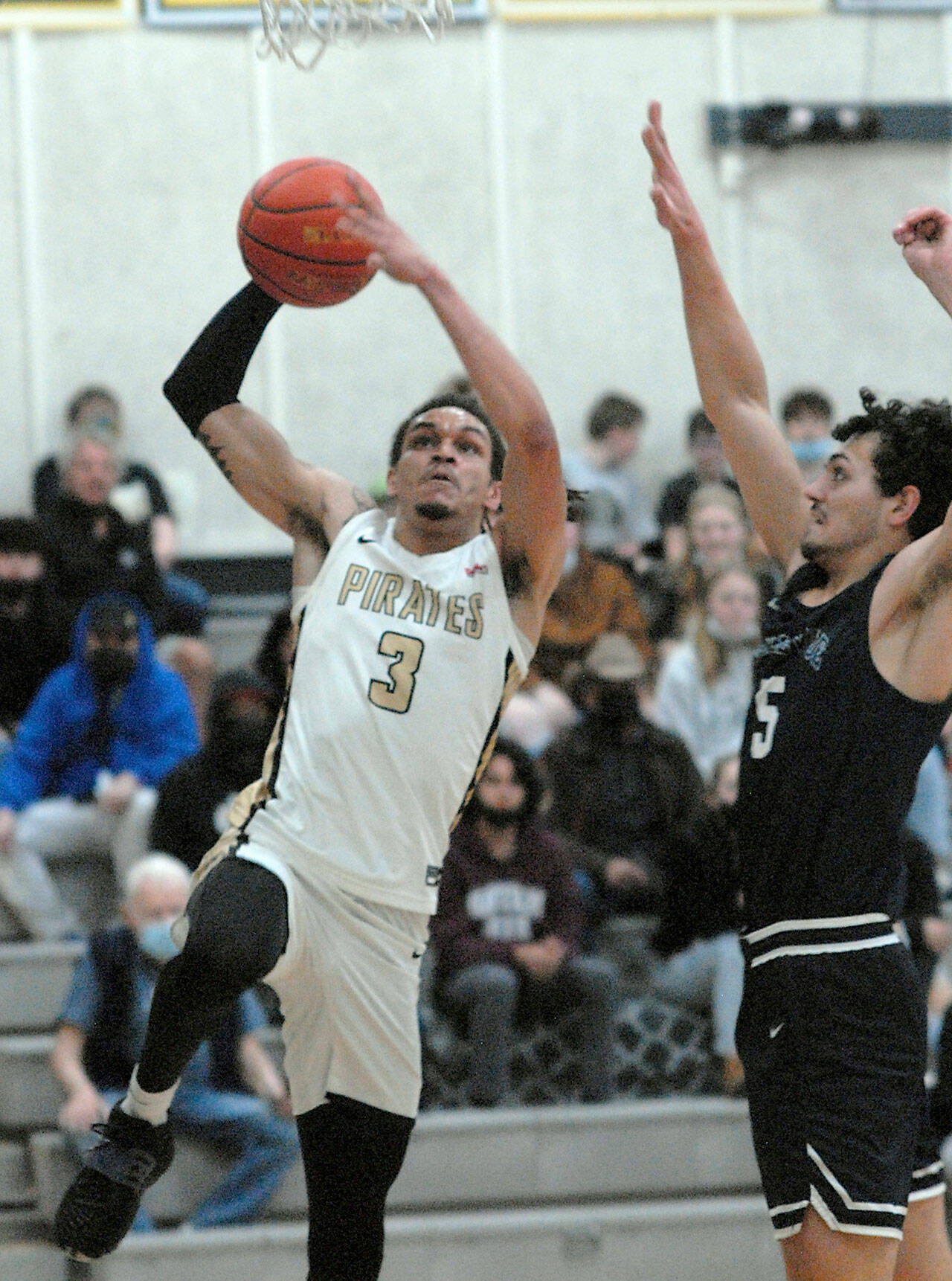 Peninsula’s Jaylin Reed, left, aims for the rim as Bellevue’s Bishop Tosi defends the lane on Saturday at Peninsula College. (Keith Thorpe/Peninsula Daily News)