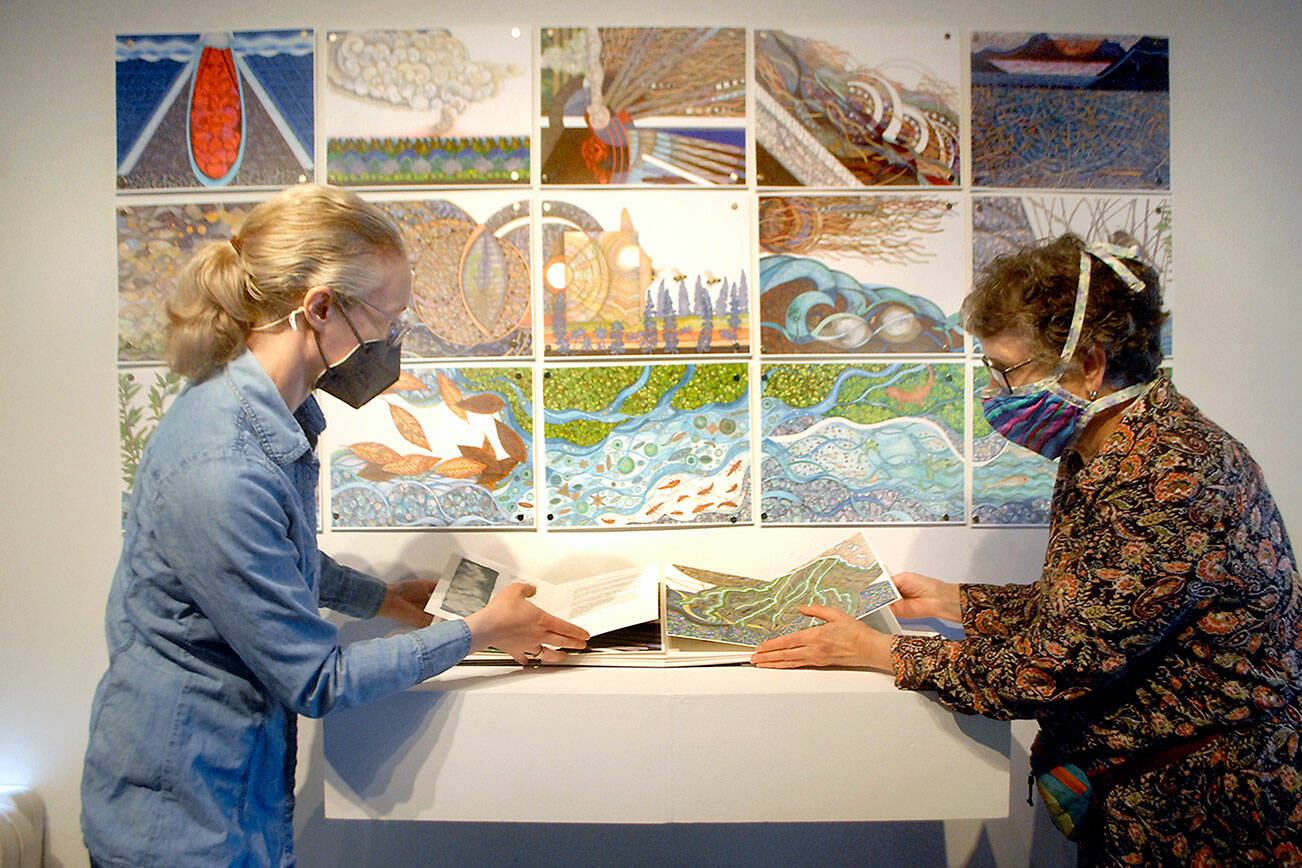 Gallery director Sarah Jane, left, and exhibit co-curator Lucia Harrison of Tacoma arrange a display that will be included in the exhibition “Science Stories: A Collaboration of Book Artists and Scientists,” which opens Friday at the Port Angeles Fine Arts Center. (Keith Thorpe/Peninsula Daily News)