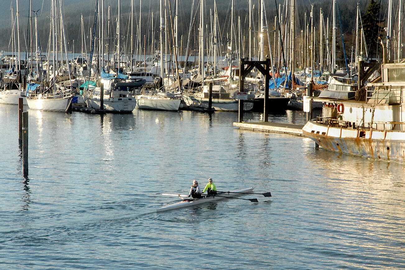 Karlena Brailey, left, and Becky Godby, both of Sequim, paddle into John Wayne Marina near Sequim on Wednesday after rowing on the waters of Sequim Bay. The pair said it was a pleasant morning for rowing in a double scull. (Keith Thorpe/Peninsula Daily News)