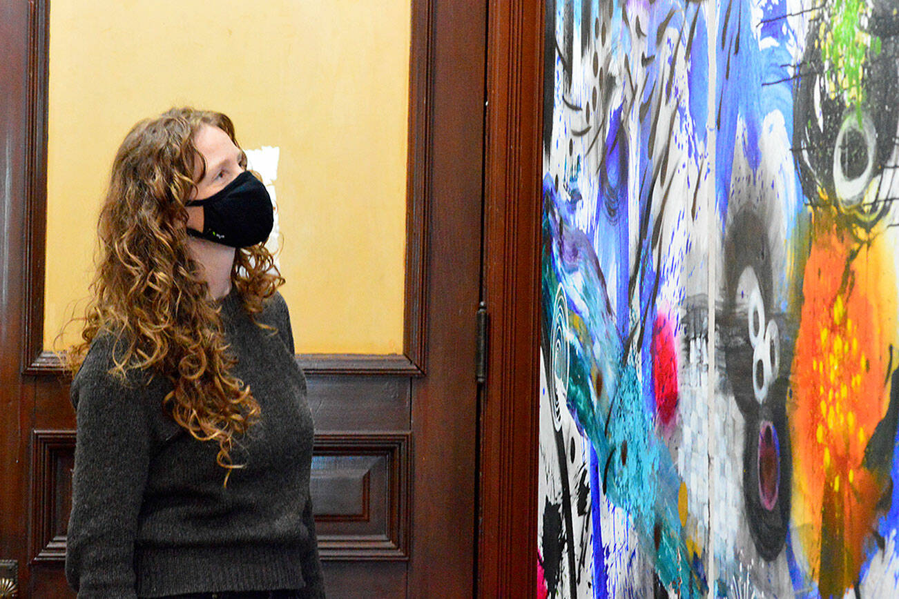 Jefferson County Historical Society executive director Shelly Leavens admires one of the Stephen Yates’ paintings just inside the Jefferson Museum of Art & History. (Diane Urbani de la Paz/Peninsula Daily News)