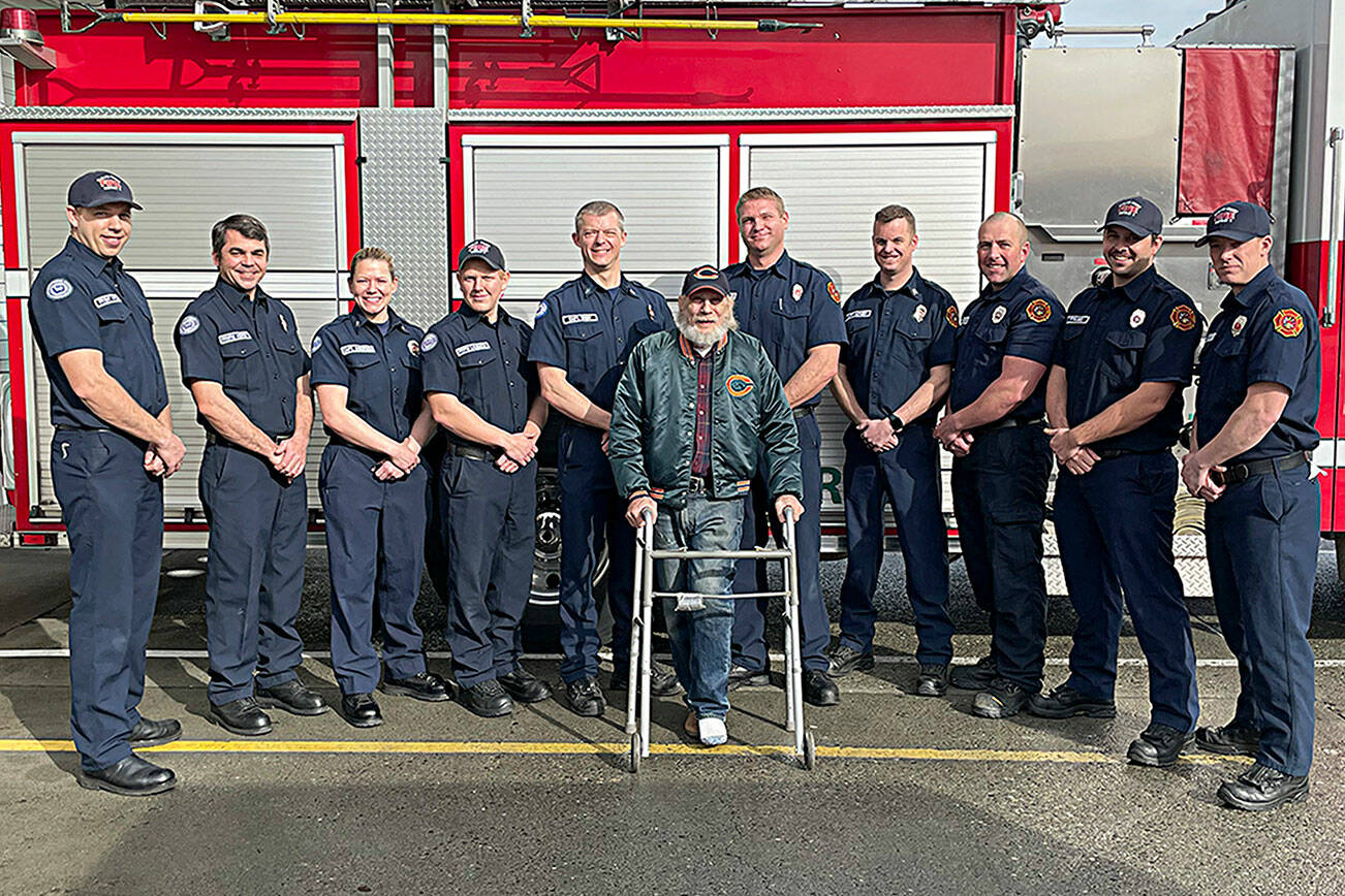 Matthew Nash/Olympic Peninsula News Group 

Clallam County Fire District 3 firefighters meet with Gregg Vella weeks after rescuing him from a house fire. Pictured from, left, are firefighter/EMT Jaisal White; firefighter/paramedic Len Horst; Capt. Stef Anderson; firefighter/paramedic Chase Laubach; Capt. Kjel Skov; Vella; firefighter/paramedic Mark Mullvain; Capt. Joel McKeen; firefighter/EMT Jared Romberg; firefighter/paramedic Casey Sires; firefighter/paramedic Jack Hueter.