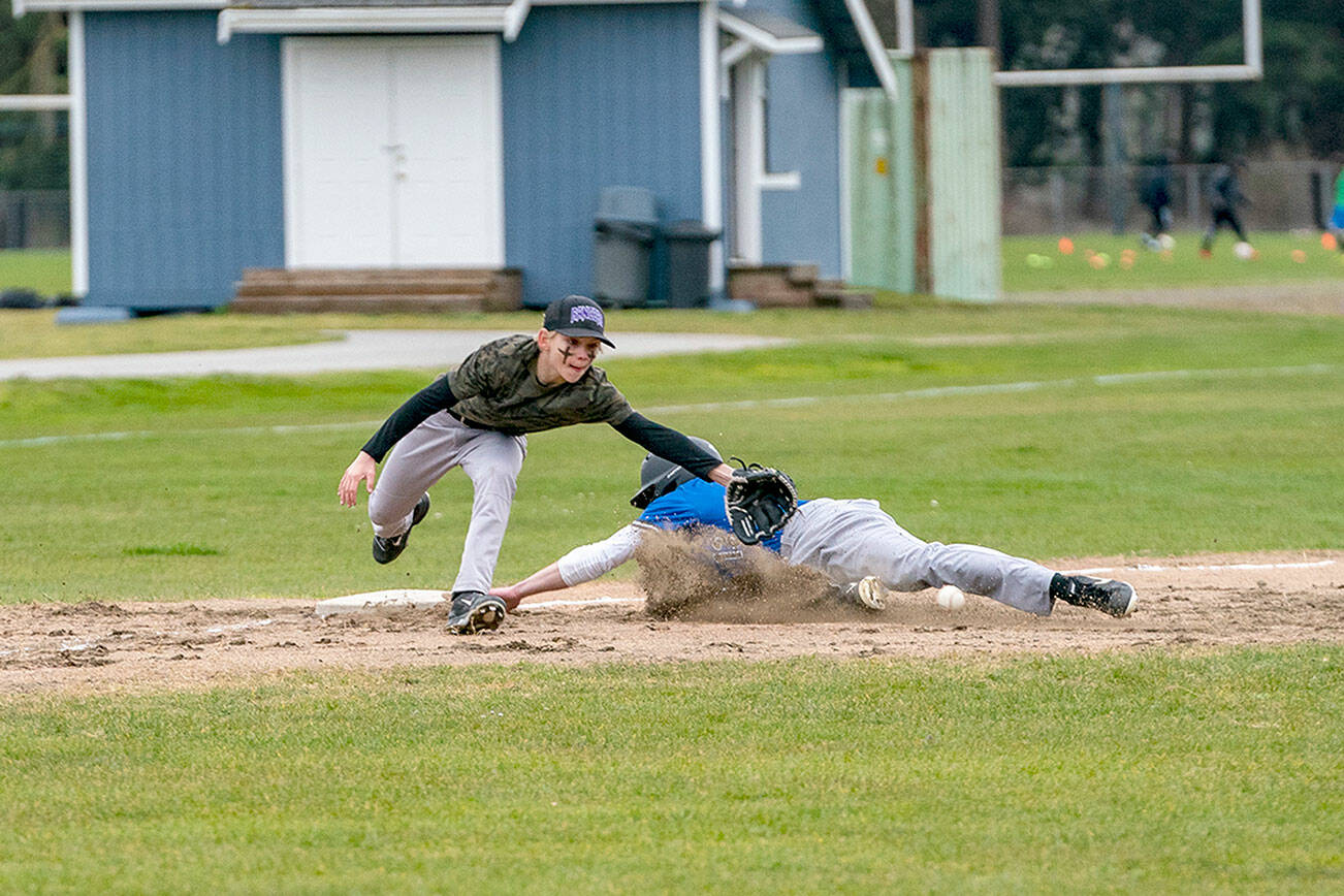 Steve Mullensky/for Peninsula Daily News
East Jefferson Rival Nathan Nisbet tags safe at third before the ball reached Quilcene’s third baseman Aiden Kate during a non-league game played in Chimacum on Monday. East Jefferson won the game 11-4.