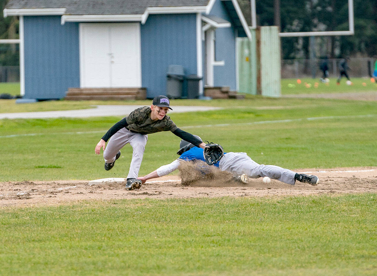Steve Mullensky/for Peninsula Daily News
East Jefferson Rival Nathan Nisbet tags safe at third before the ball reached Quilcene’s third baseman Aiden Kate during a non-league game played in Chimacum on Monday. East Jefferson won the game 11-4.