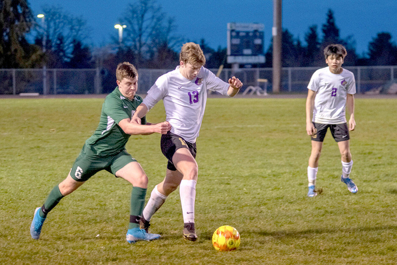 Emily Matthiessen/Olympic Peninsula News Group
Sequim's Brandon Charters fights off Port Angeles' Caleb McLarty for possession as the Wolves' Kristian Mingoy looks on during Sequim's rivalry victory over the Roughriders.