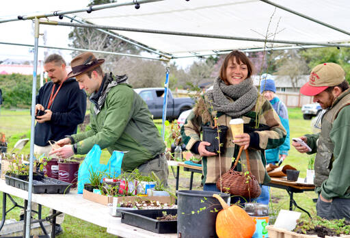 Plant and Seed Exchange Organizer Ashley Kehl, left in hat, mingles with visitors including Bryan DeCaterina of Port Townsend, at right, and Daryl Dietrich of Quilcene on Sunday at Shy Acre Farm during the annual event in Port Townsend. Held on the first day of spring, there was a chilly breeze and a good turnout. (Diane Urbani de la Paz/Peninsula Daily News)