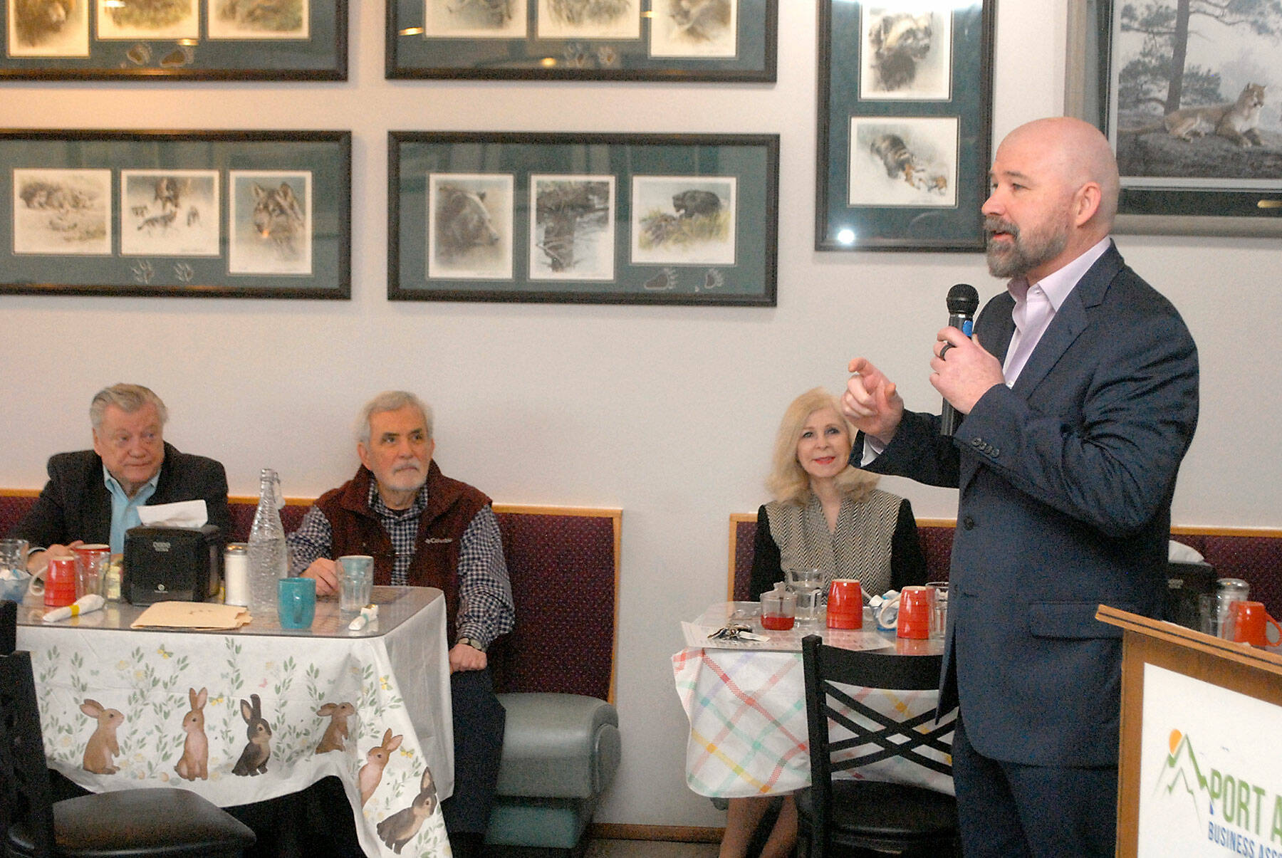 Ward, vice president of Sound Publishing and publisher of the six-day-per-week Peninsula Daily News and the weekly Sequim Gazette and Forks Forum, right, speaks about changes to the newspapers during a Tuesday morning breakfast with members of the Port Angeles Business Association. Ward described the switch to delivery by mail, adjustments to the publication schedule and the general health of the newspaper group. Among those in attendence were business association members, from left, Dick Pilling, former PDN publisher John Brewer and former mayor Cherie Kidd. (Keith Thorpe/Peninsula Daily News)