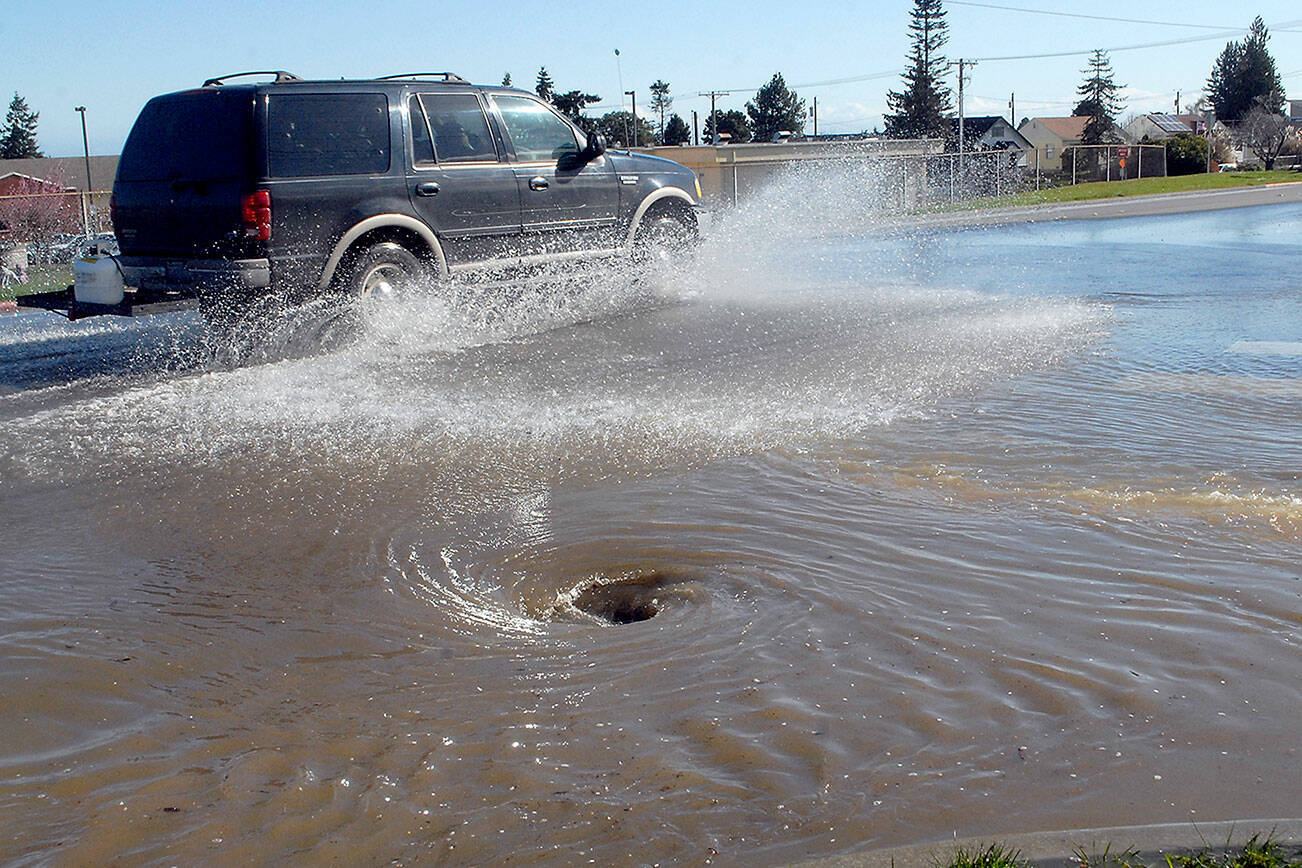 Keith Thorpe/Peninsula Daily News 

Traffic splashes along East Lauridsen Boulevard as water from a main break slows into a storm drain at South Chase Street on Wednesday after a 6-inch water line burst in the 200 block of East Orcas Avenue in Port Angeles. Repairs were expected to be completed by about 6 p.m. Wednesday, according to a report posted late Wednesday afternoon on the city website. Some 54 customers were affected and were under a boil-water advisory, city officials said.