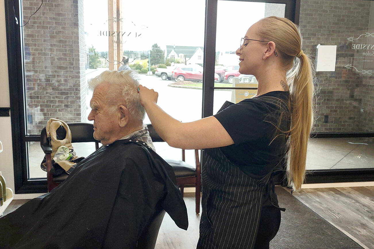 Nikhita Rogers gives her grandfather, Art Rogers, a haircut in her new barbershop.