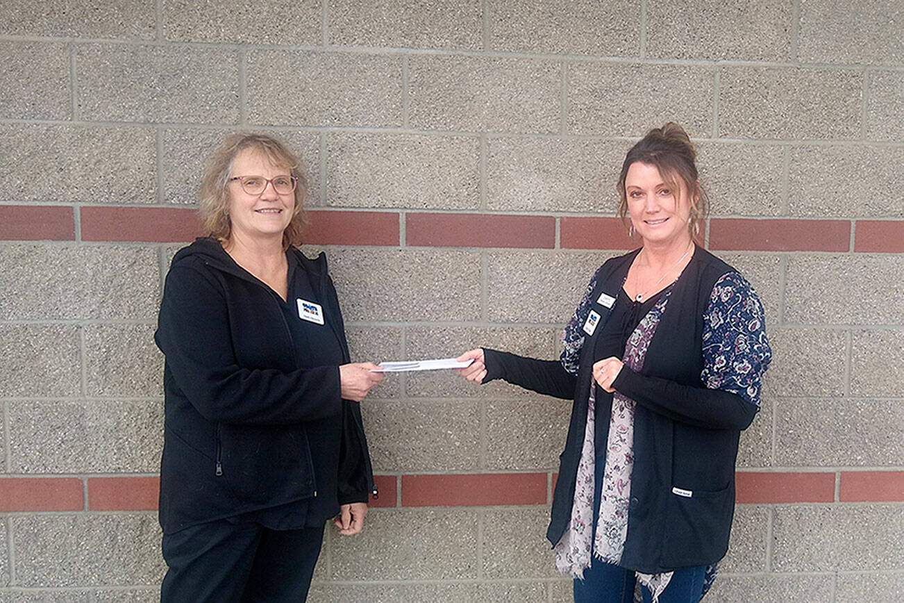 Heidi Albrecht, left, treasurer for Coats for Kids, receives a check from Cheryl Stipe of Jim’s Pharmacy.