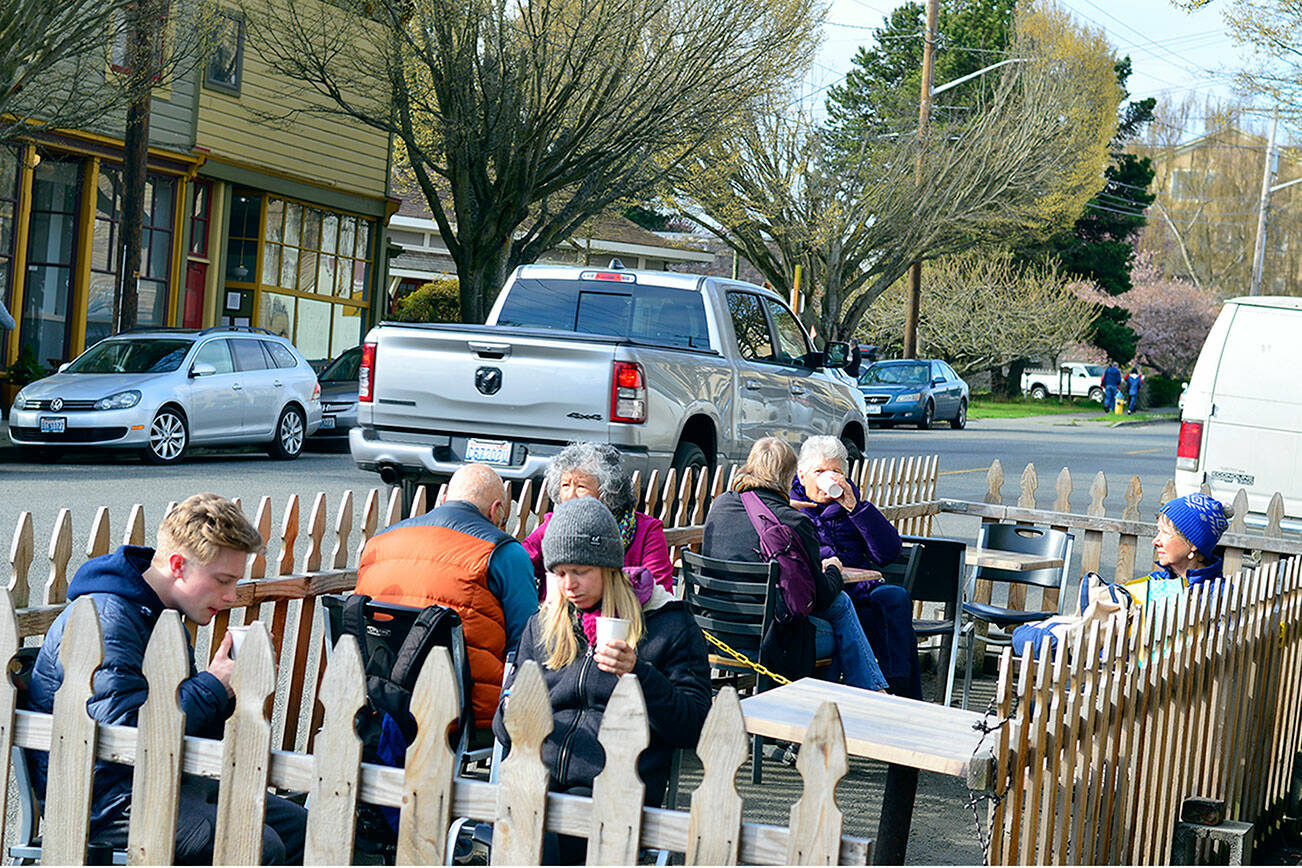 Vehicles pass a streatery on Lawrence Street, where patrons of Seal Dog Coffee stopped in Saturday morning. (Diane Urbani de la Paz/Peninsula Daily News)