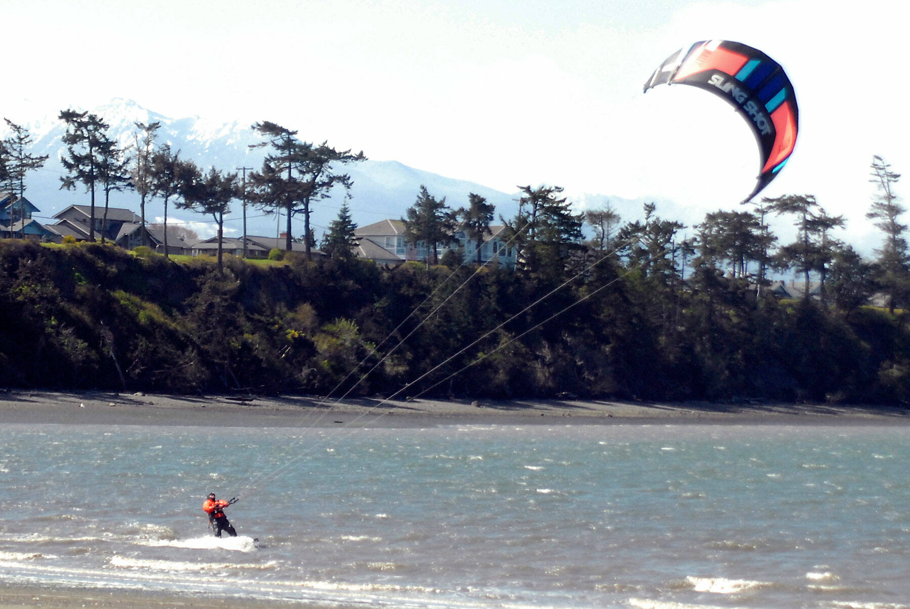 Barney Lund of Kent takes to the water off Dungeness Bay with his kite board on a blustery Tuesday north of Sequim. Stiff westerly breezes prompted Lund to try his hand at harnessing the wind, he said. (Keith Thorpe/Peninsula Daily News)
