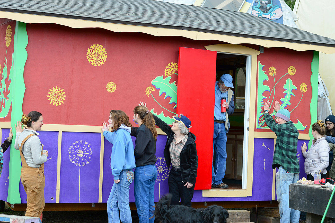 Several of the workers who built Meadow Manor, a tiny house destined for a farmworker village, celebrate its completion at the Community Boat Project last Friday. (Diane Urbani de la Paz/Peninsula Daily News)