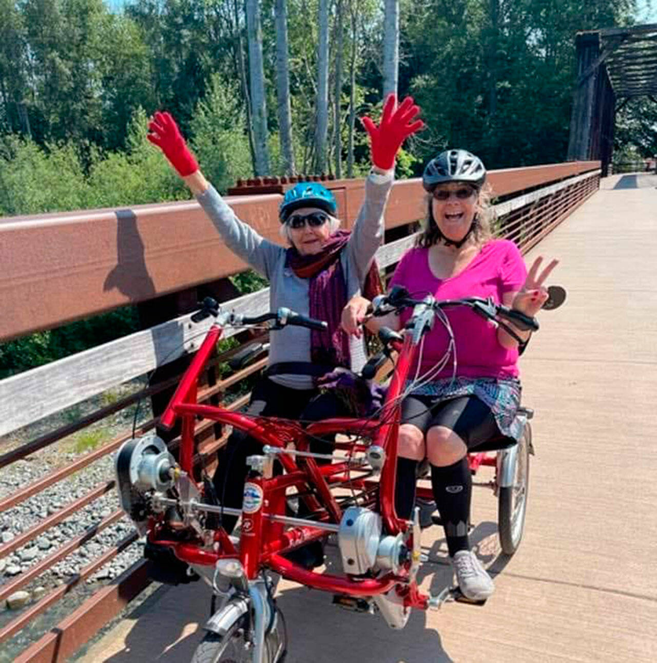 Rita McCabe, left, and Sequim Wheelers Vice President Lanie Cates enjoy a ride on a side-byside tandem bike on the Olympic Discovery Trail. Sequim Wheelers are preparing for their fifth season this spring. (Nicole Lepping)