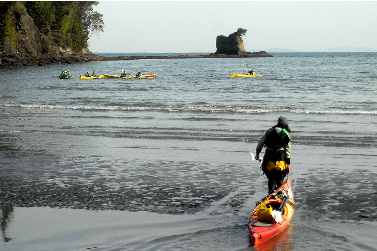 Keith Thorpe/Peninsula Daily News
Nina Sarmiento, a sea kayak guide with Adventures Through Kayaking, pulls out to lead a group of kayakers in the waters of Freshwater Bay west of Port Angeles on Thursday. The group was paddling out to explore the area around the Bachelor Rock sea stack, accessible by water from Freshwater Bay County Park.