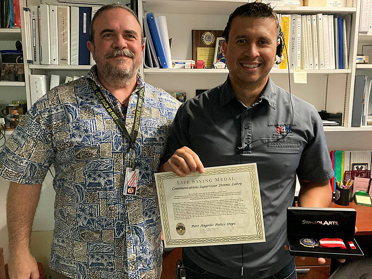 The Port Angeles Police Department, represented by PenCom deputy director Karl Hatton, left, honored Dennis Laboy, a communications supervisor from Sequim. (City of Port Angeles)