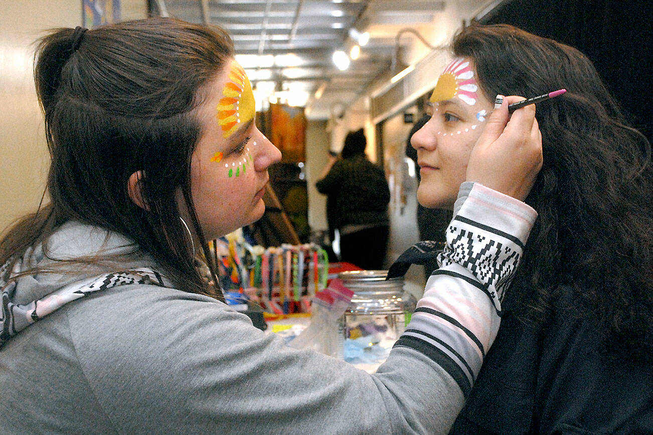 Keith Thorpe/Peninsula Daily News
Soohia Art of Port Angeles, right, gets her face painted by Emma Gockerell of Sequim-based Emma-gine Painting & Parties during Friday's pop-up market at the inaugural Squatchcon 2022 Comic & Arts Convention at The Wharf on the Port Angeles waterfront. The convention continues today and Sunday with a variety of activities.