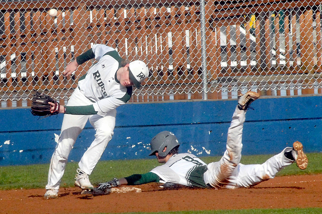 Keith Thorpe/Peninsula Daily News
Port Angeles third baseman Elijah Flodstrom, left, lets the ball get past him after it struck Peninsula baserunner Tony Buchanan and bounced away on a third base steal on Friday at Port Angeles Civic Field.