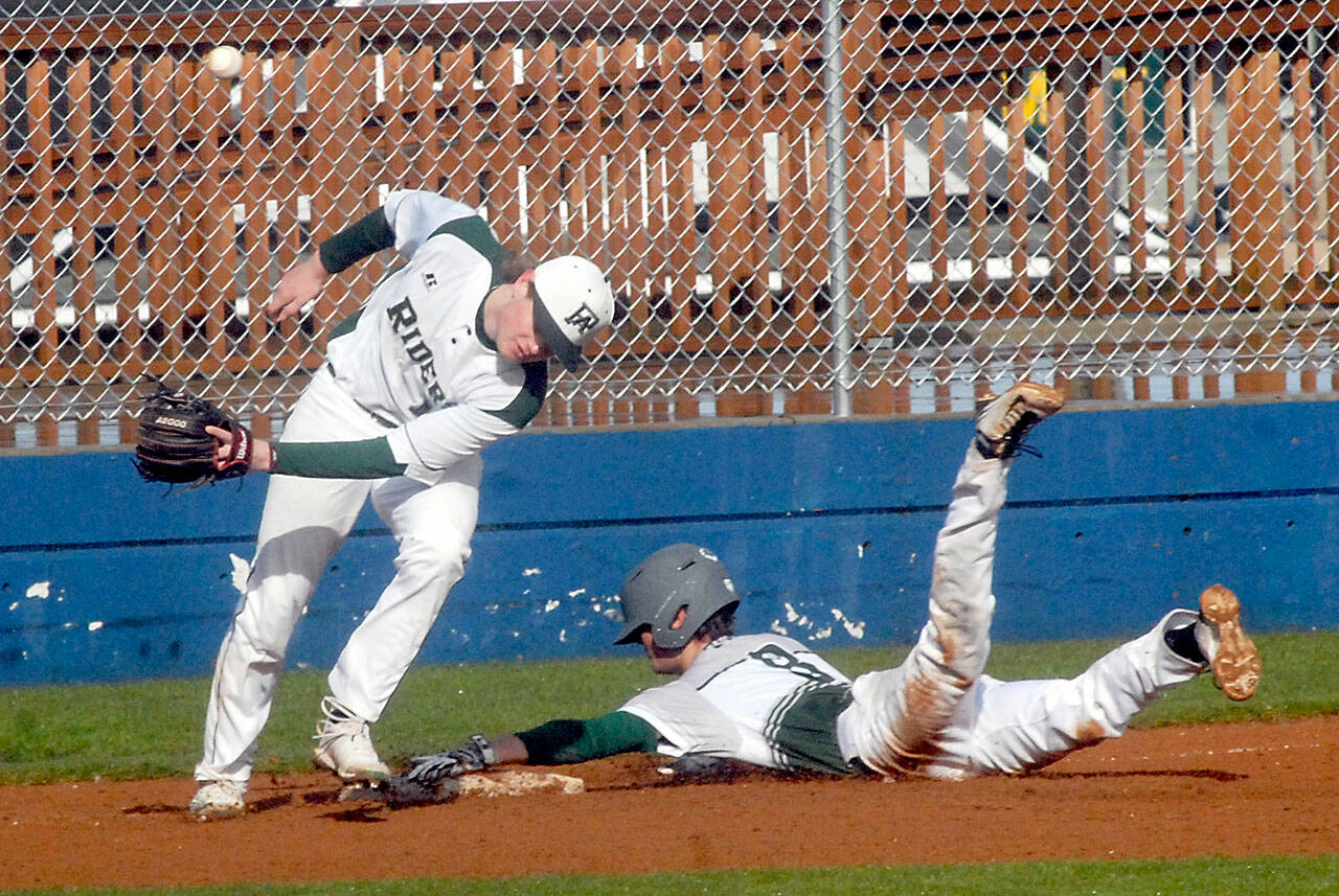 Port Angeles third baseman Elijah Flodstrom, left, lets the ball get past him after it struck Peninsula baserunner Tony Buchanan and bounced away on a third base steal on Friday at Port Angeles Civic Field. (Keith Thorpe/Peninsula Daily News)
