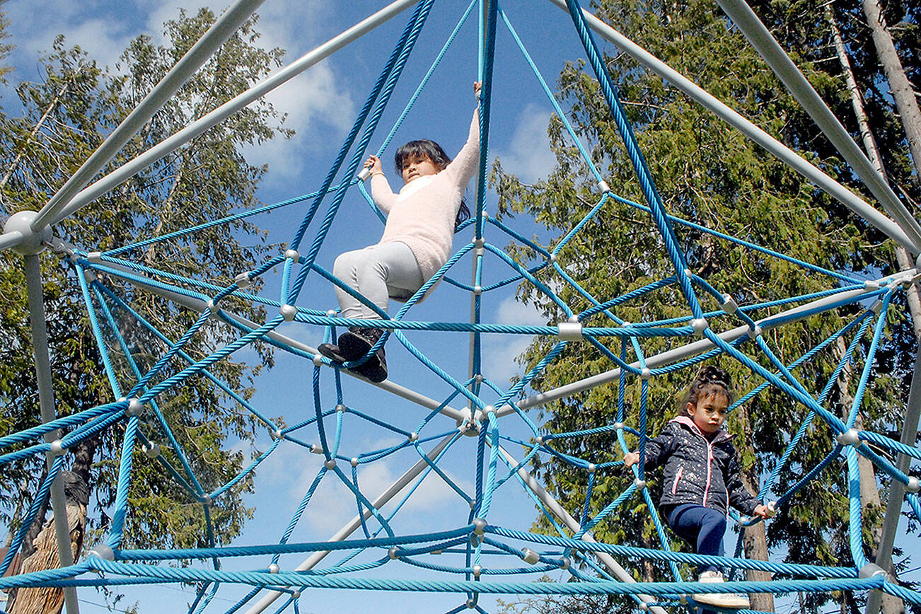 Keith Thorpe/Peninsula Daily News
Aria Barrette, 7, top, and her sister, Alyeah Barrette, 5, both of Olympia, spend time on a jungle gym at the Dream Playground in Erickson Park in Port Angeles on Saturday. The pair were in Port Angeles visiting relatives and took an afternoon to visit the playground.