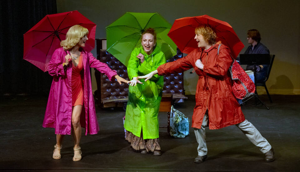 Old friends Honey, Patsy and Vern played by Mindy Gelder, Susan Cates and Rebecca Gilbert psych each other up to go to the bingo hall during a deluge. Behind, musical director Morgan Bartholick plays the keyboard. (Emily Matthiessen/Olympic Peninsula News Group)