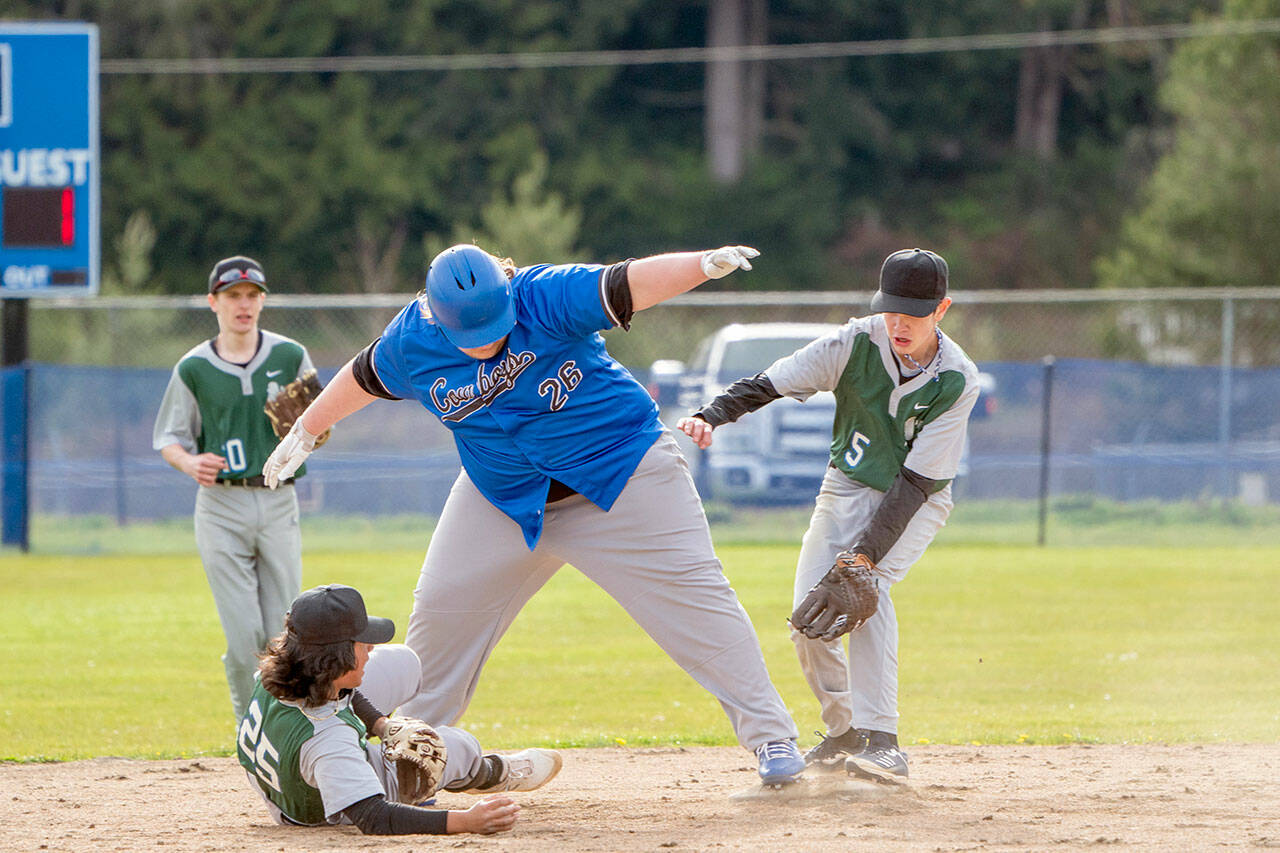 East Jefferson Rival Chris Fair maintains his balance on 2nd base so as to not get tagged out by Charles Wrights Brandon Bennett, who has the ball in his hand, during a game in Chimacum on Wednesday. Charles Wrights Cory Mallrie, 10, and Cole Caalim, 5, are backing up the play. (Steve Mullensky/for Peninsula Daily News)