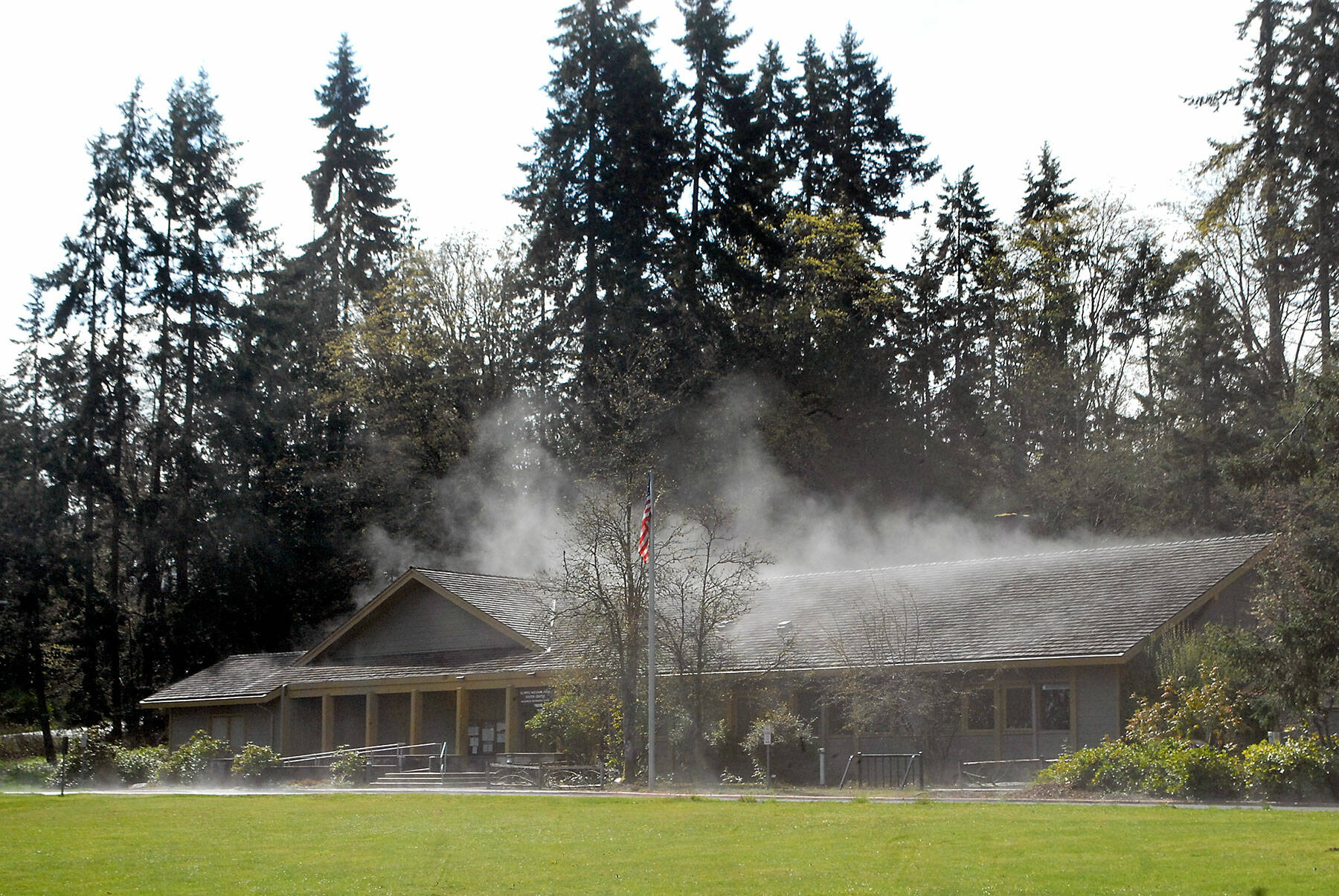 Steam rises from the roof and front driveway of the Olympic National Park Visitor Center on Thursday in Port Angeles after direct sunlight reached its rain-drenched shingles. (Keith Thorpe/Peninsula Daily News)