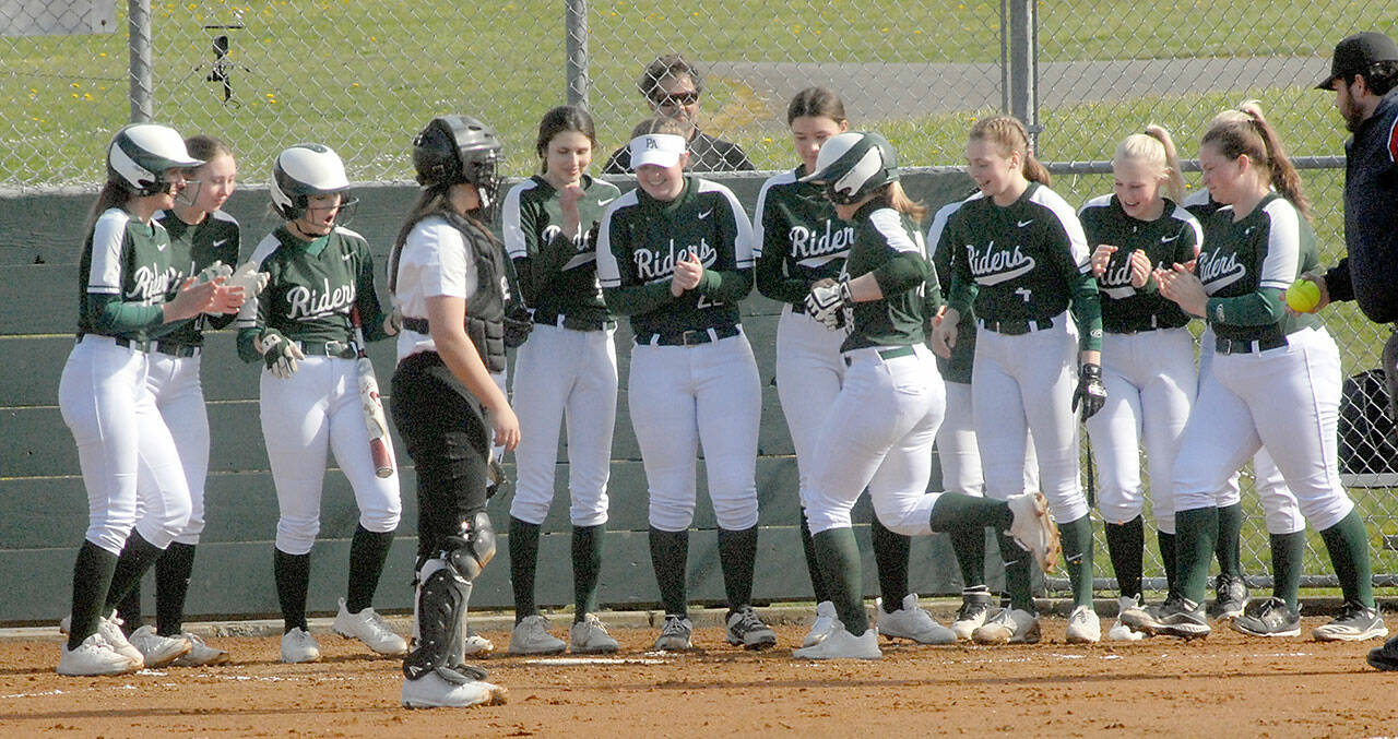 Port Angeles’ Lily Halberg, right center, is greeted by her teammates as she crosses home plate after a solo home run, the second of the first inning while Kingston catcher Audrey Rienstra looks on during Thursday’s game in Port Angeles. Keith Thorpe/Peninsula Daily News