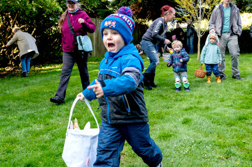 A 4-year-old boy runs excitedly after the perfect Easter egg during the 92nd Port Townsend Elks Lodge Easter Egg Hunt at Chetzemoka Park on Sunday. About 100 kids ages 0-8 scattered to look for decorated eggs, some of which were redeemable for prizes. (Steve Mullensky/for Peninsula Daily News)