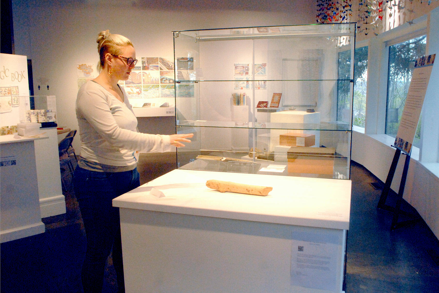 Rachel Storck, community engagement manager for the Port Angeles Fine Arts Center, points out a display case where exhibit pieces were taken during a weekend burglary. (Keith Thorpe/Peninsula Daily News)