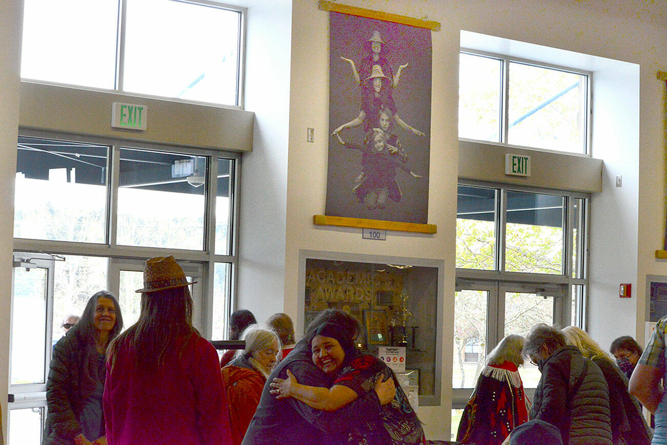 Above the crowd in the Chimacum School Commons is Brian Goodman’s family portrait of, from top, Cindy, Azuriah, Phineas and Zishe Sylvester. (Diane Urbani de la Paz/Peninsula Daily News)