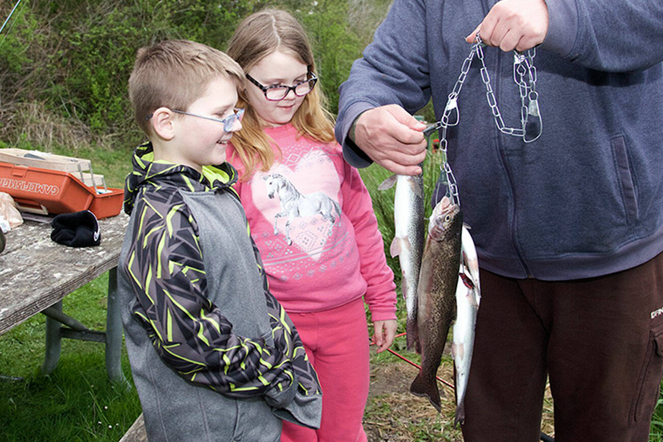 Steve Mullensky/for Peninsula Daily News


Jim Dunn, from Port Orchard, show off his trout catch to son, Joshua, 8,  and daughter Alia, 10, while fishing on the opening day of trout fishing at Anderson Lake.