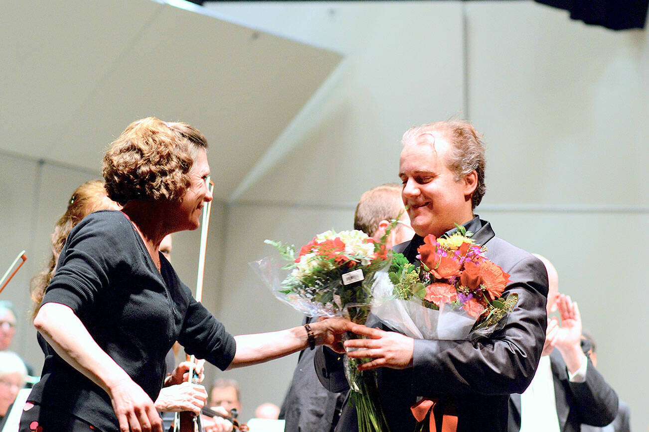 Piano soloist Josu De Solaun, pictured in February 2020 receiving flowers from Port Angeles Symphony volunteer Dorthe Grube Porter, will return as one of the guest artists in the orchestra’s 90th anniversary season. Tickets for the 2022-2023 series of 13 concerts will go on sale this summer. (Diane Urbani de la Paz/Peninsula Daily News)