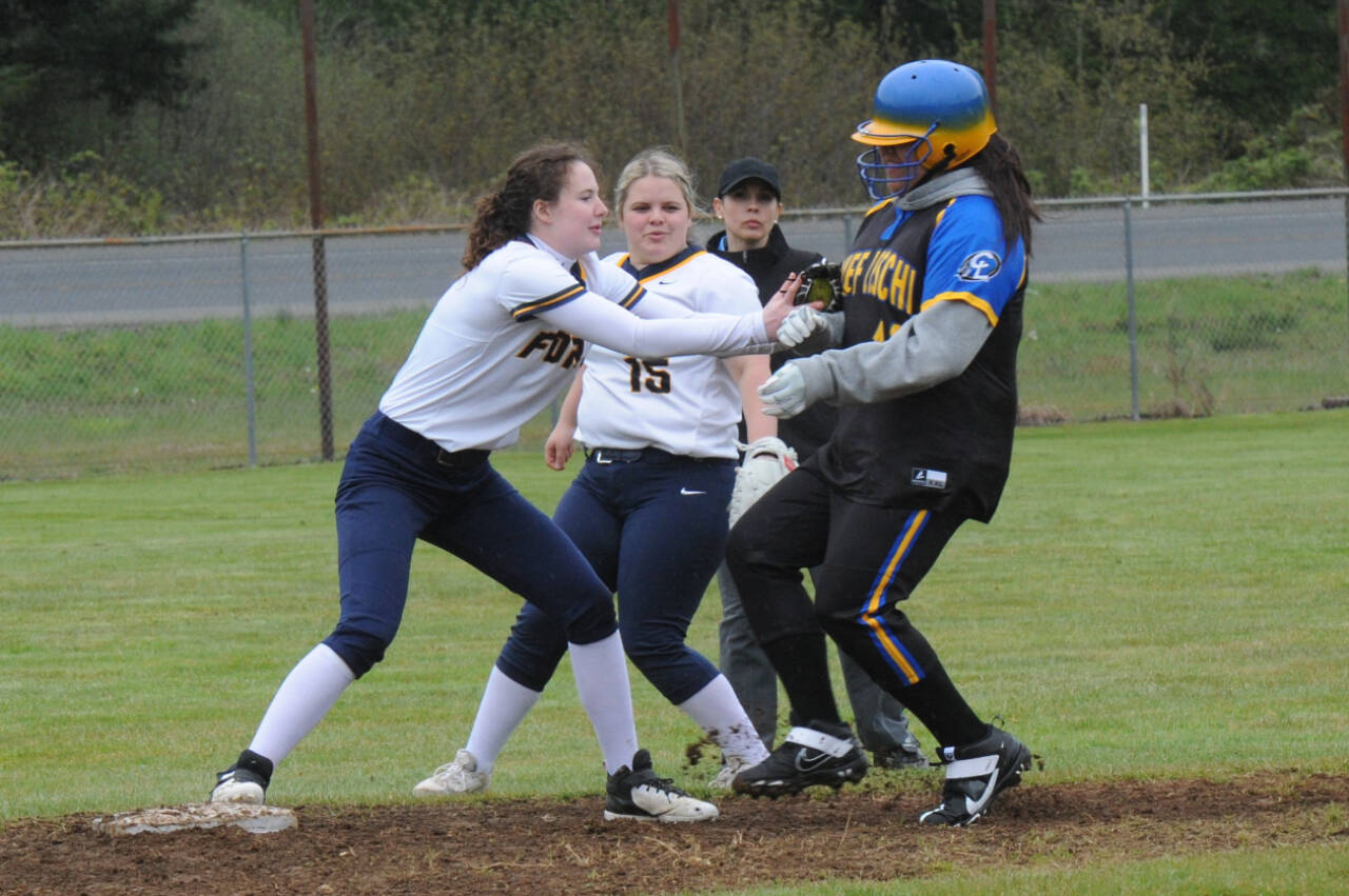 Forks centerfielder Keira Johnson hustles to cover second base tagging out a Chief Leschi runner. Looking on is second baseman Nicole Winger. The Spartans won a doubleheader by the scores of 28-0 and 17-0. (Lonnie Archibald/for Peninsula Daily News)