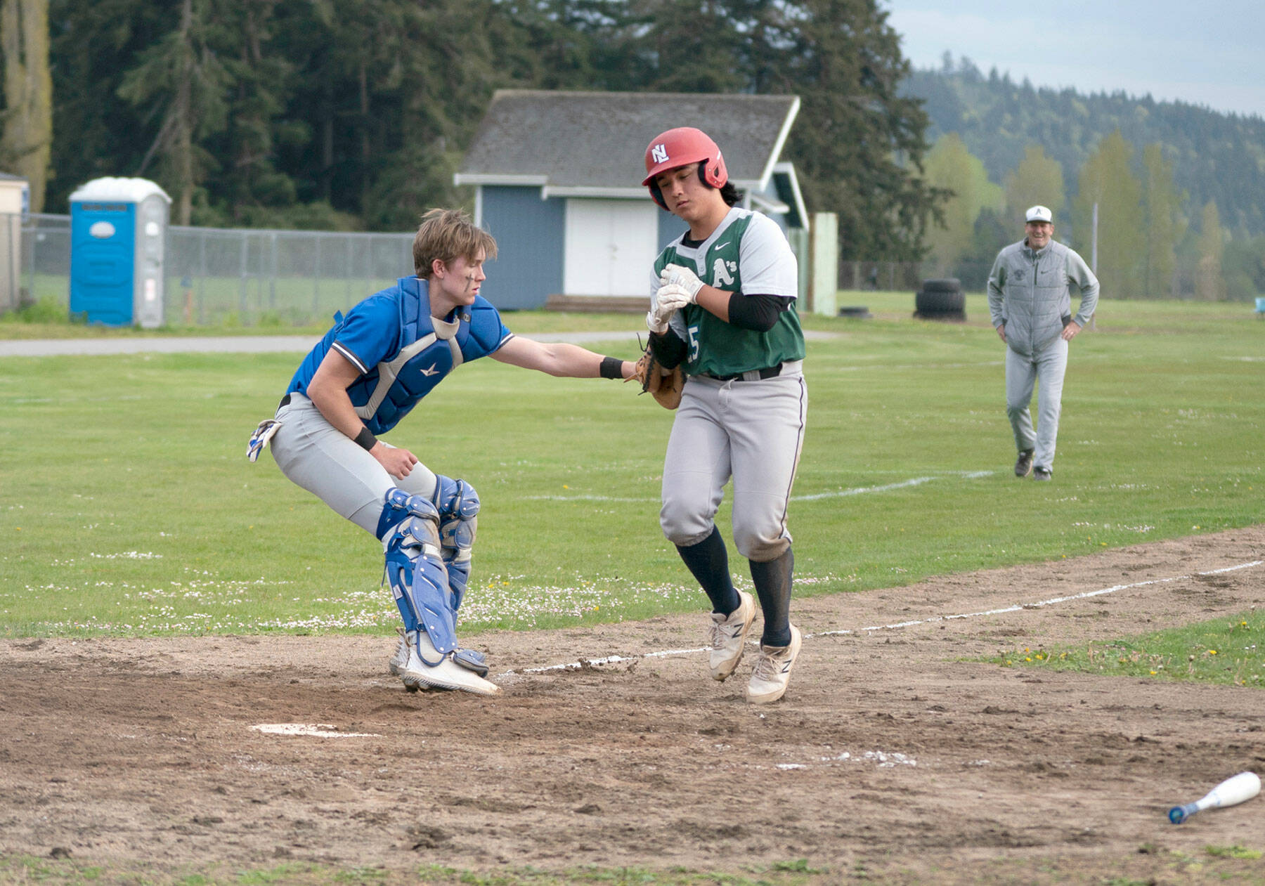 East Jefferson catcher Cash Holmes tags out Charles Wright’s Nico Rose as he tries to score a run in the second game of a Wednesday doubleheader played in Chimacum. (Steve Mullensky/for Peninsula Daily News)