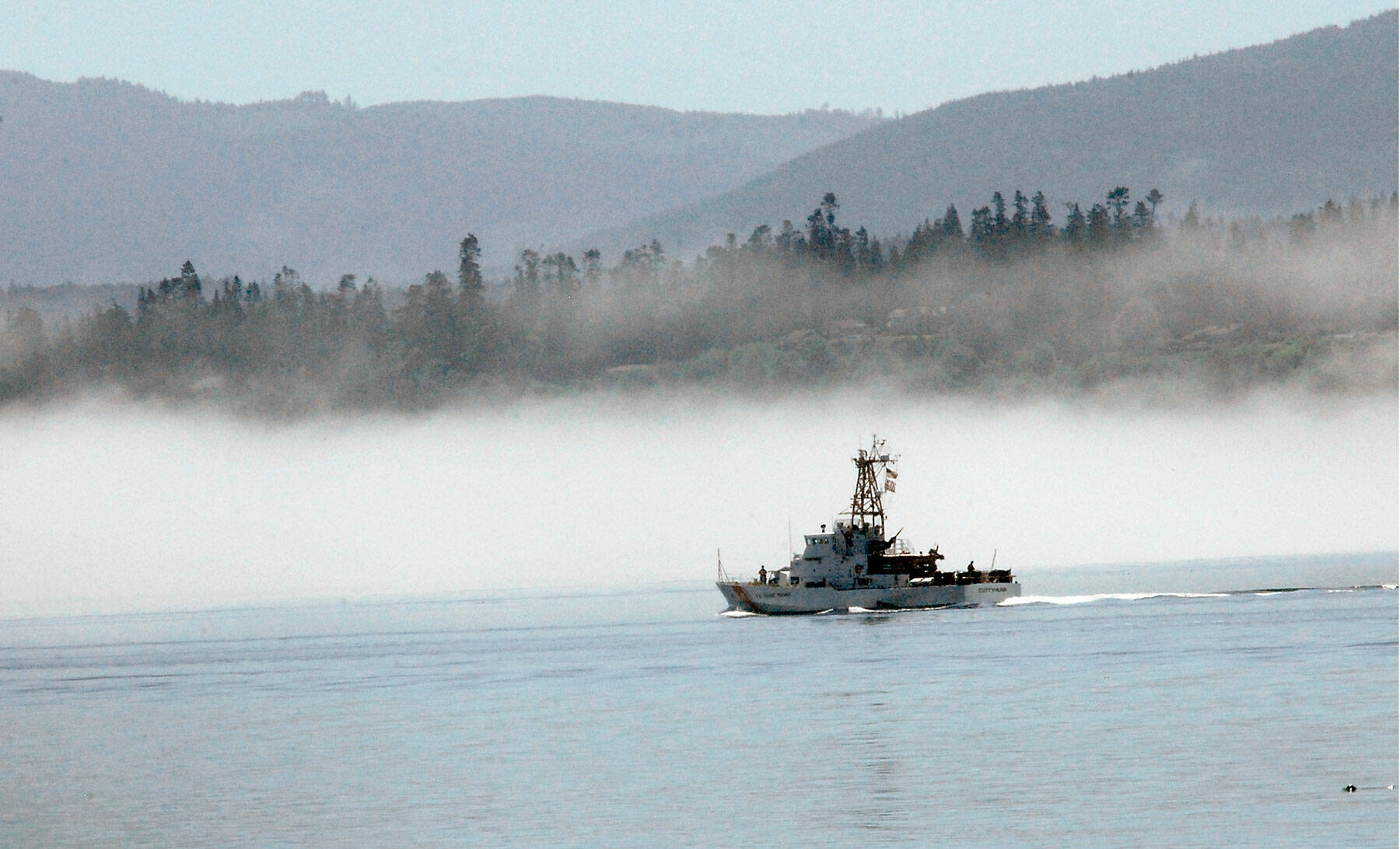 The U.S. Coast Guard cutter Cuttyhunk sails across Port Angeles Harbor against a backdrop of fog hugging the shoreline. in June 2020. (Keith Thorpe/Peninsula Daily News)