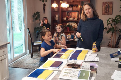 Josephine Johnson, second from right, and family get to work on her artwork fundraiser to aid refugees from the Russian invasion of Ukraine. (Kyle Johnson)